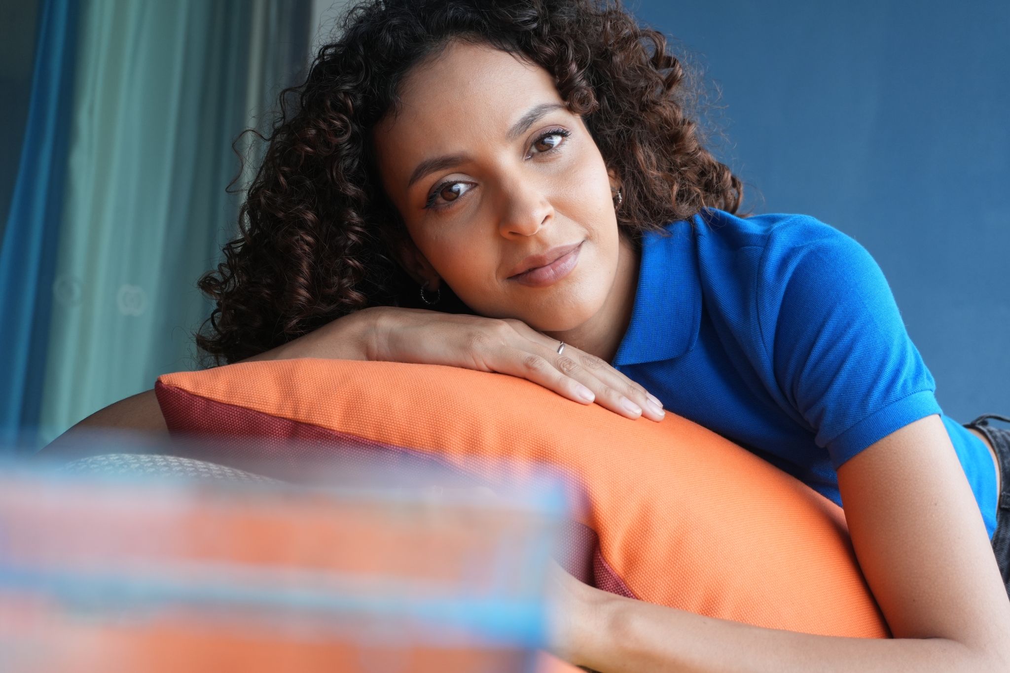 Sample image of a woman leaning against a sofa, with the glass in the foreground blurred