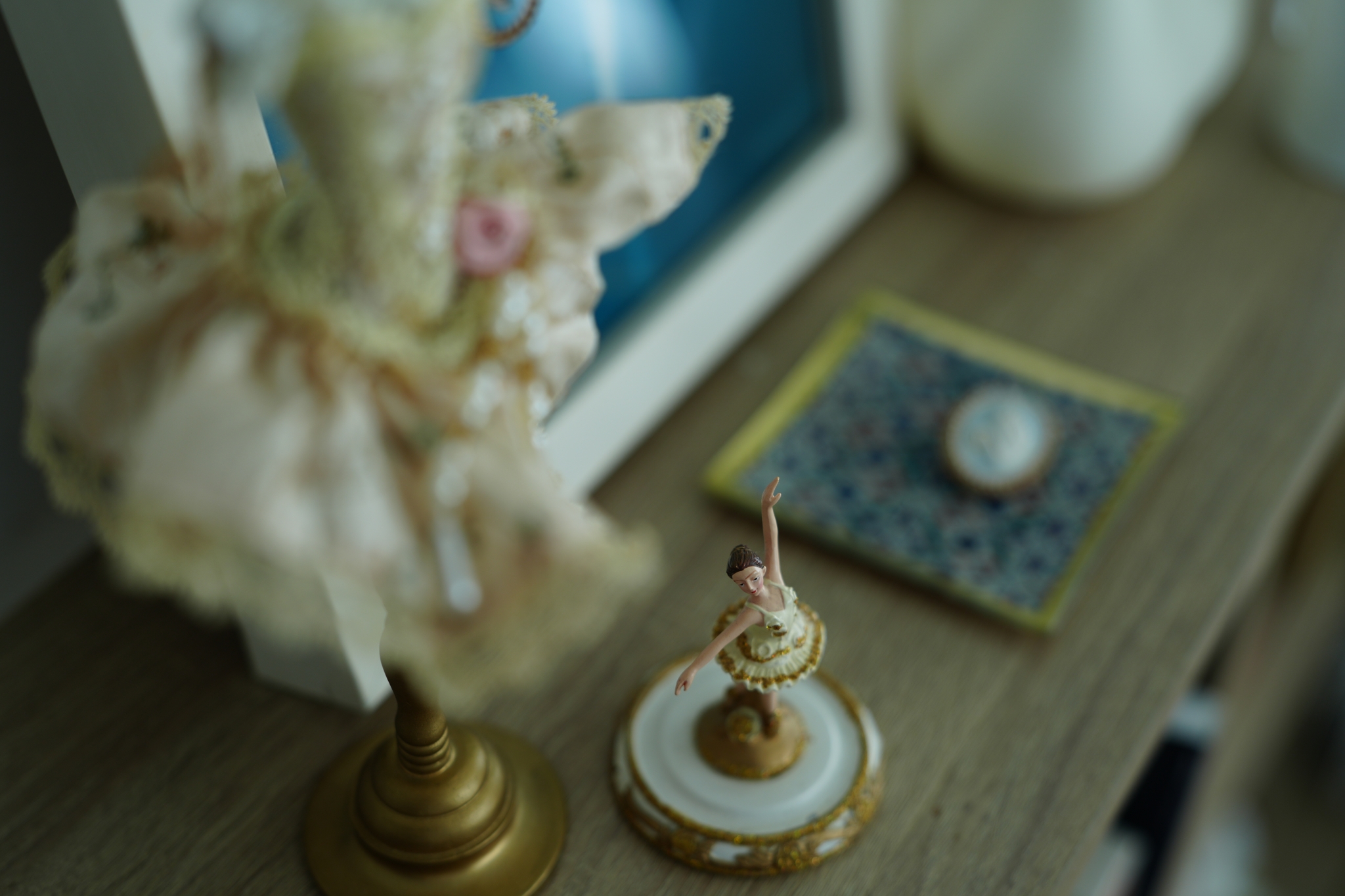 An example where ballerina figurines are arranged on a table, with a beautiful bokeh effect prominent in the foreground Click to open modal