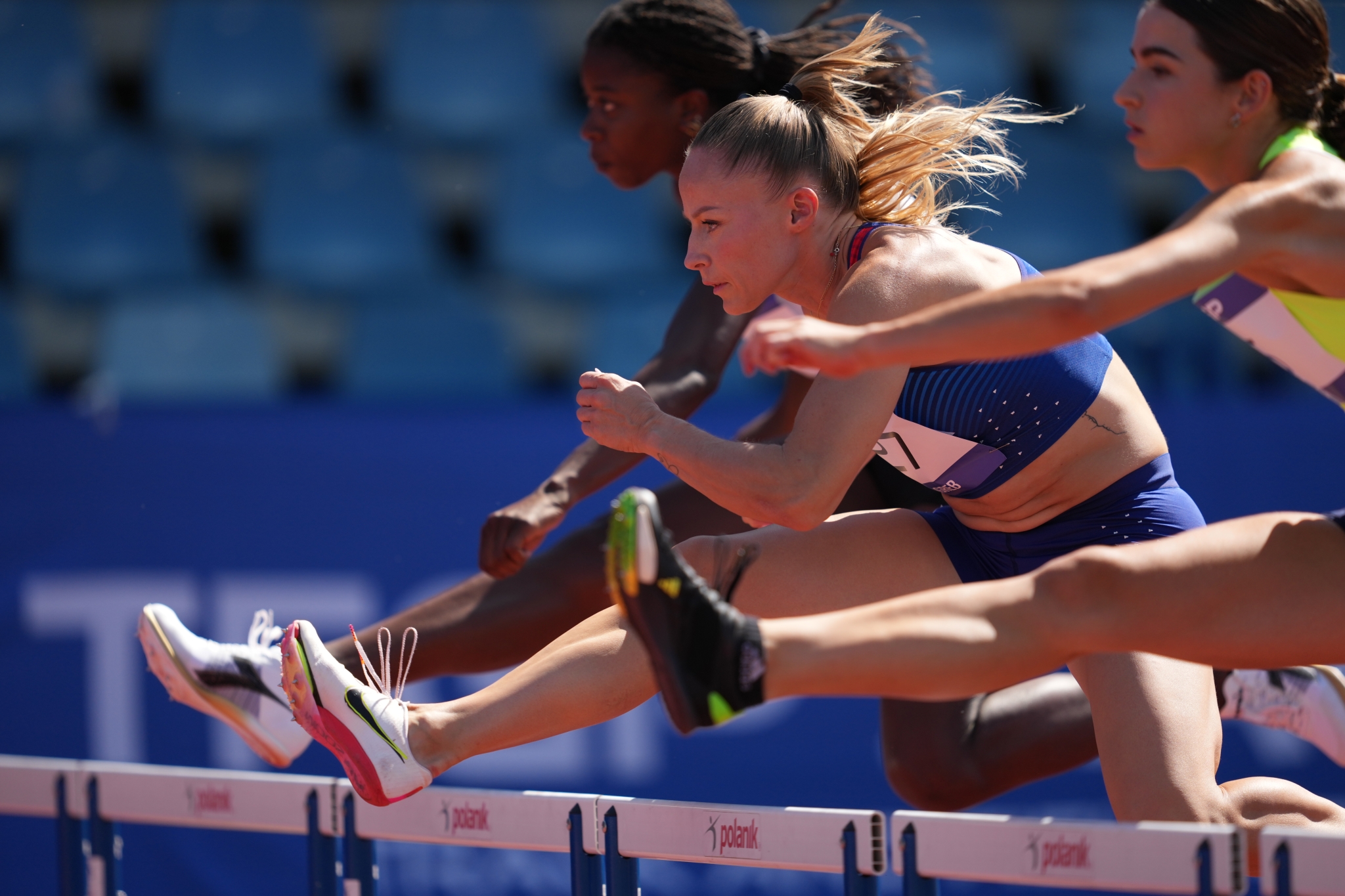 Example image of 3 track athlete women jumping over hurdles Click to open modal