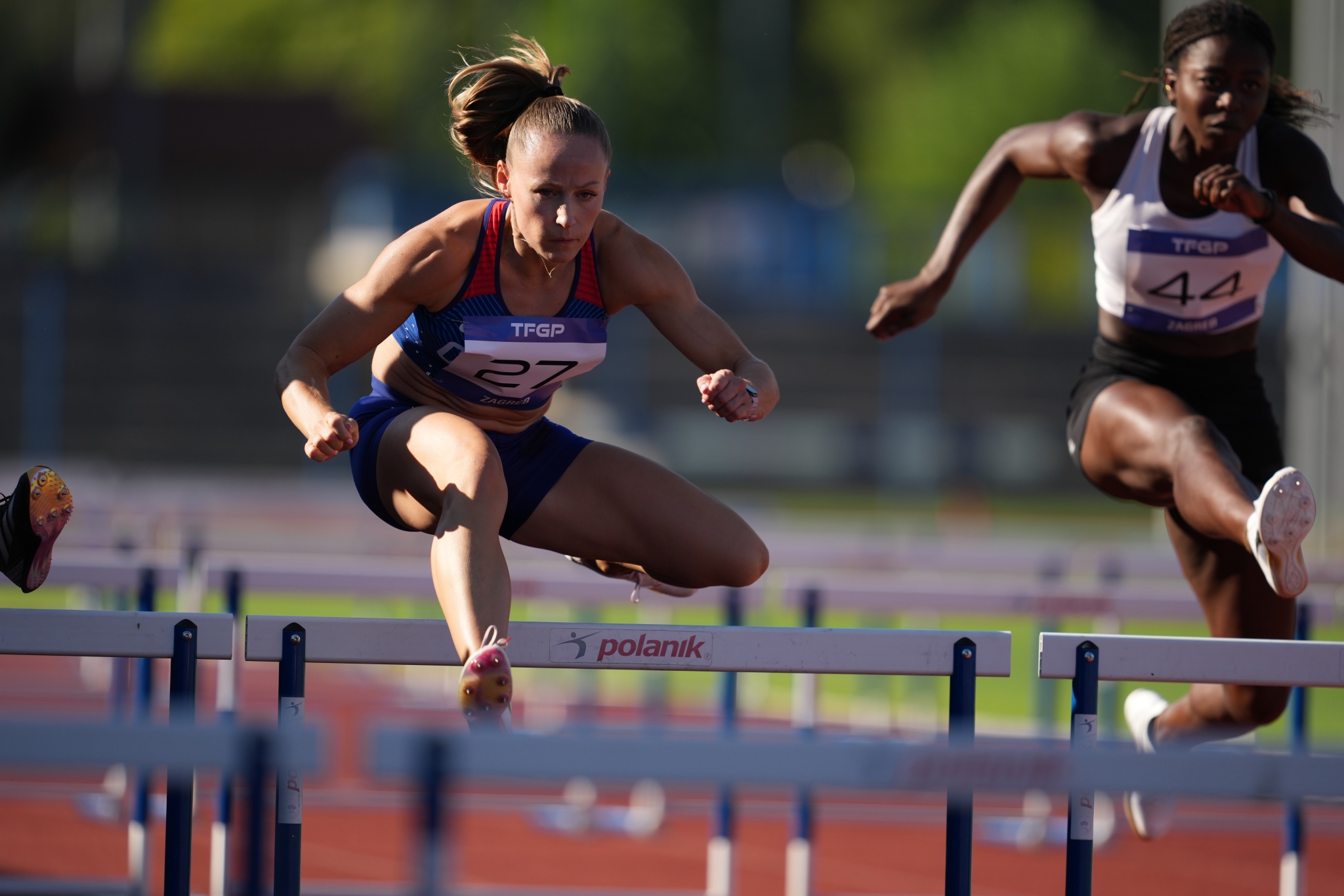 Example image showing 2 women jumping over the hurdle Click to open modal