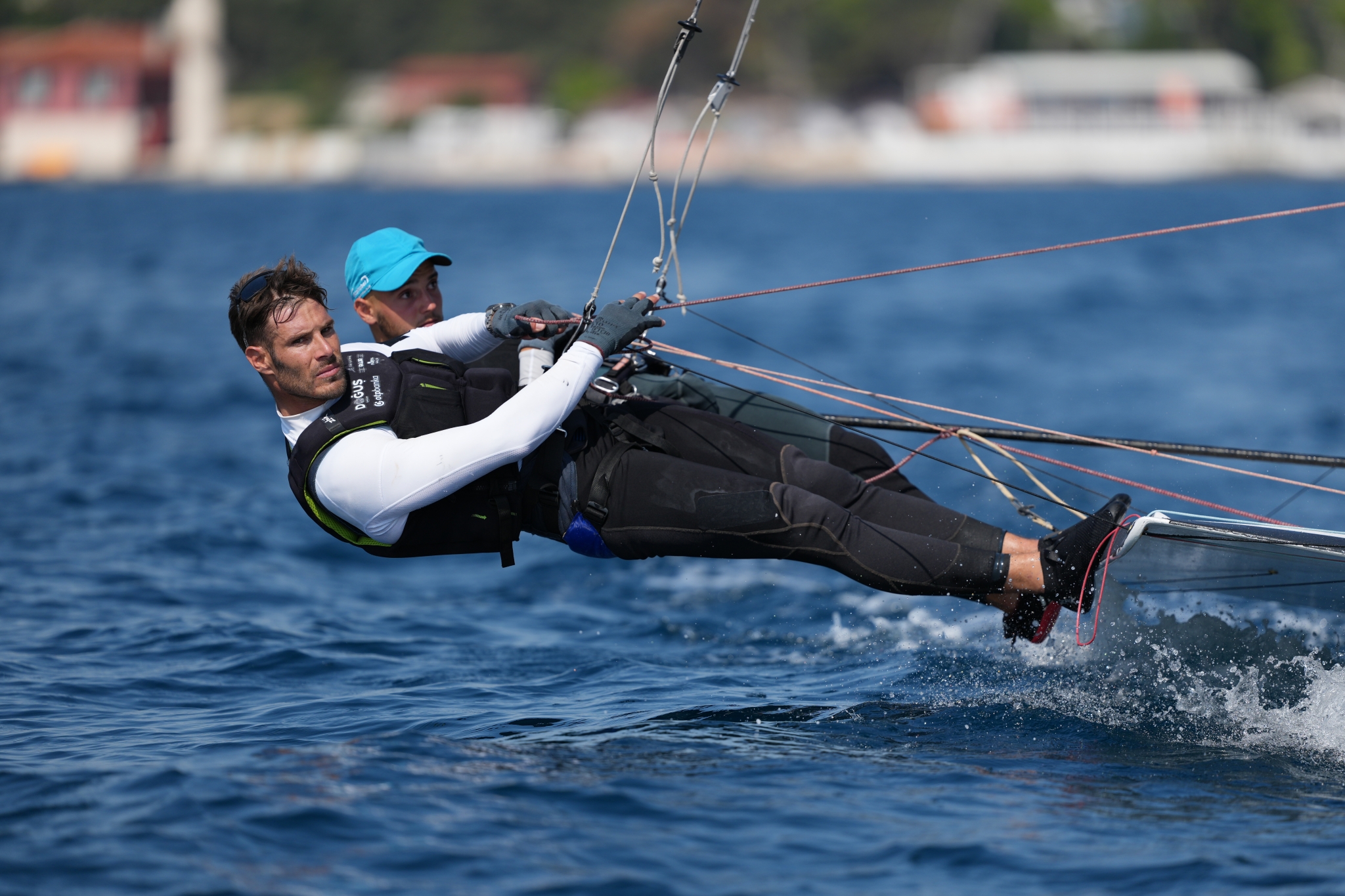 Example image showing two men leaning out on a yacht at speed, with focus on the eye of the man in front Click to open modal