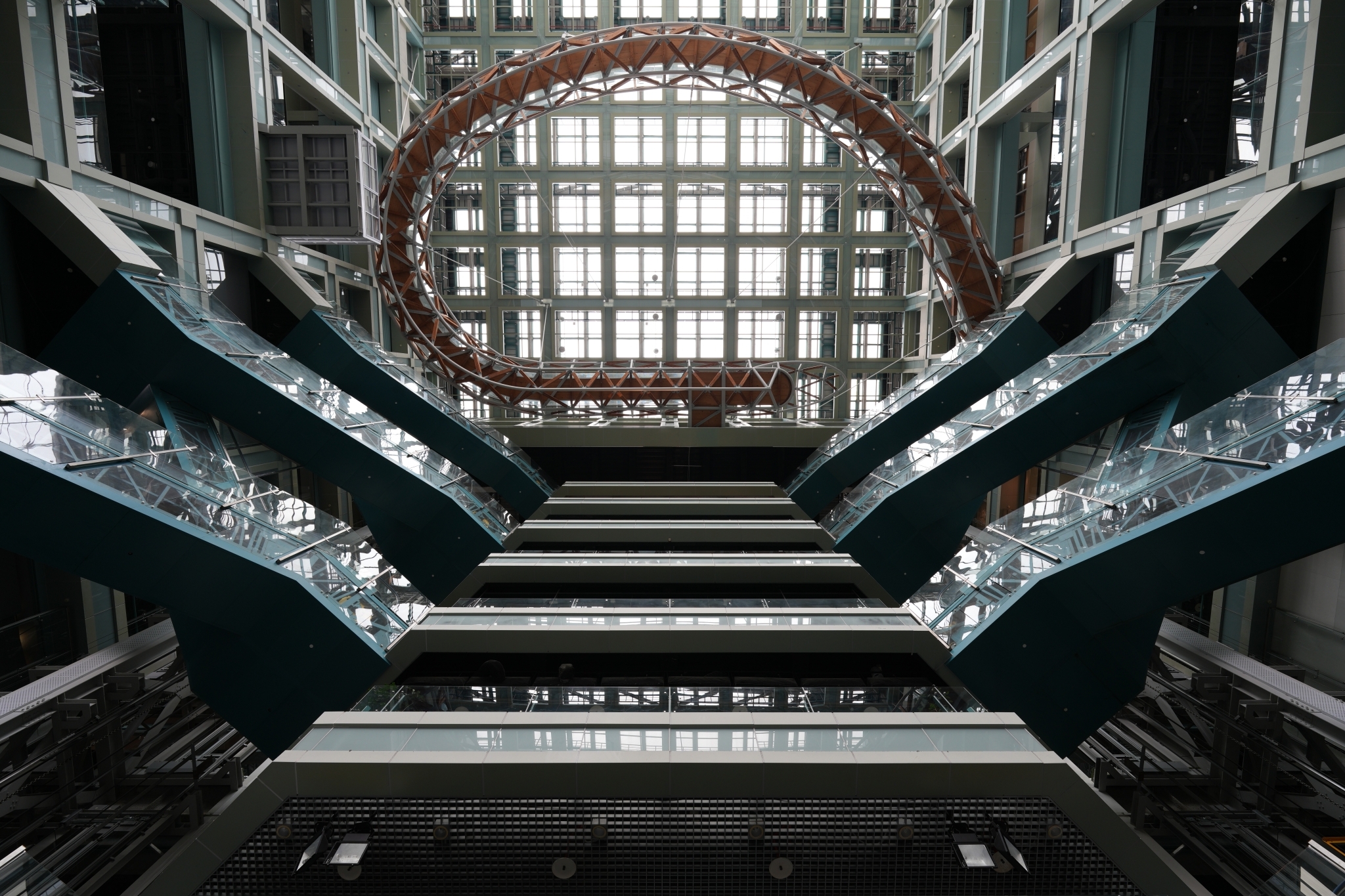 A high-resolution photograph capturing a unique design of a wide ceiling. In the foreground, there is a red circular shape, while light filters through the glass ceiling behind it, without fringing. Click to open modal